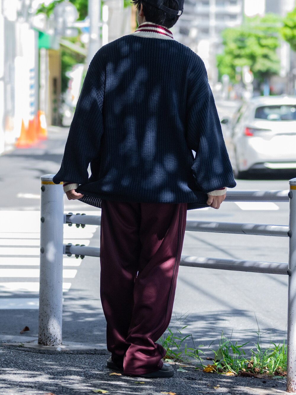 ブルー系のニット/セーター、グレー系のその他パンツ、ブラック系のスニーカーを着用したメンズの秋コーディネートの4枚目の写真