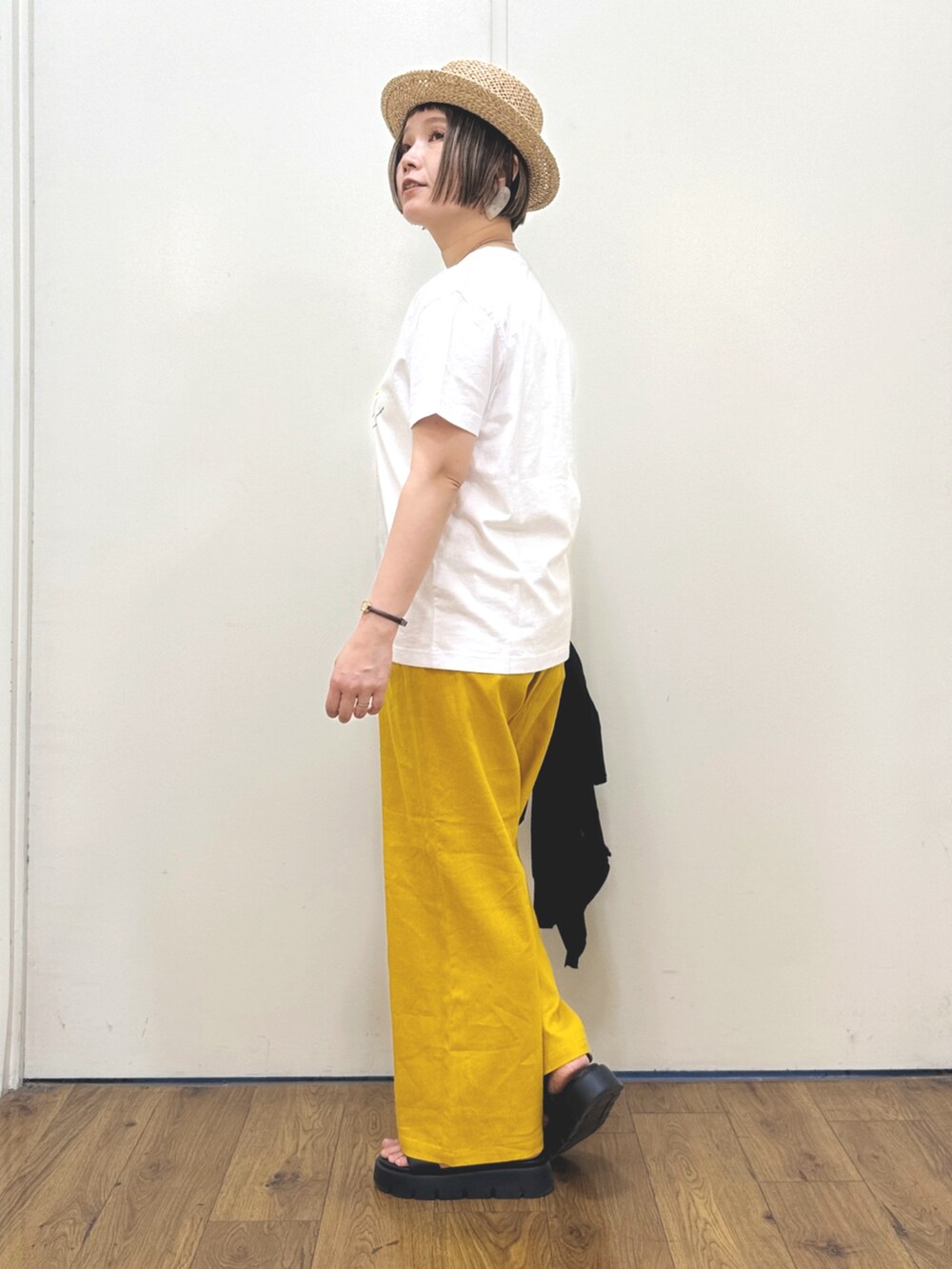 ブラック系のカーディガン/ボレロ、ホワイト系のTシャツ/カットソー、ブラック系のサンダルを着用したレディースの春コーディネートの4枚目の写真