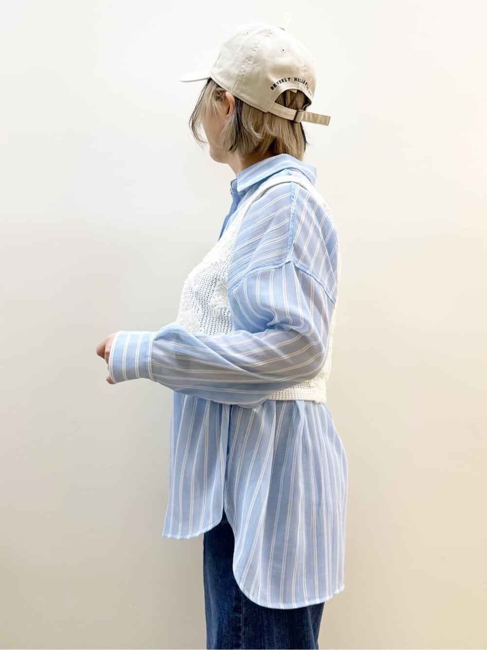 ブルー系のシャツ/ブラウス、ホワイト系のベスト、ブルー系のデニムパンツを着用したレディースの春コーディネートの4枚目の写真