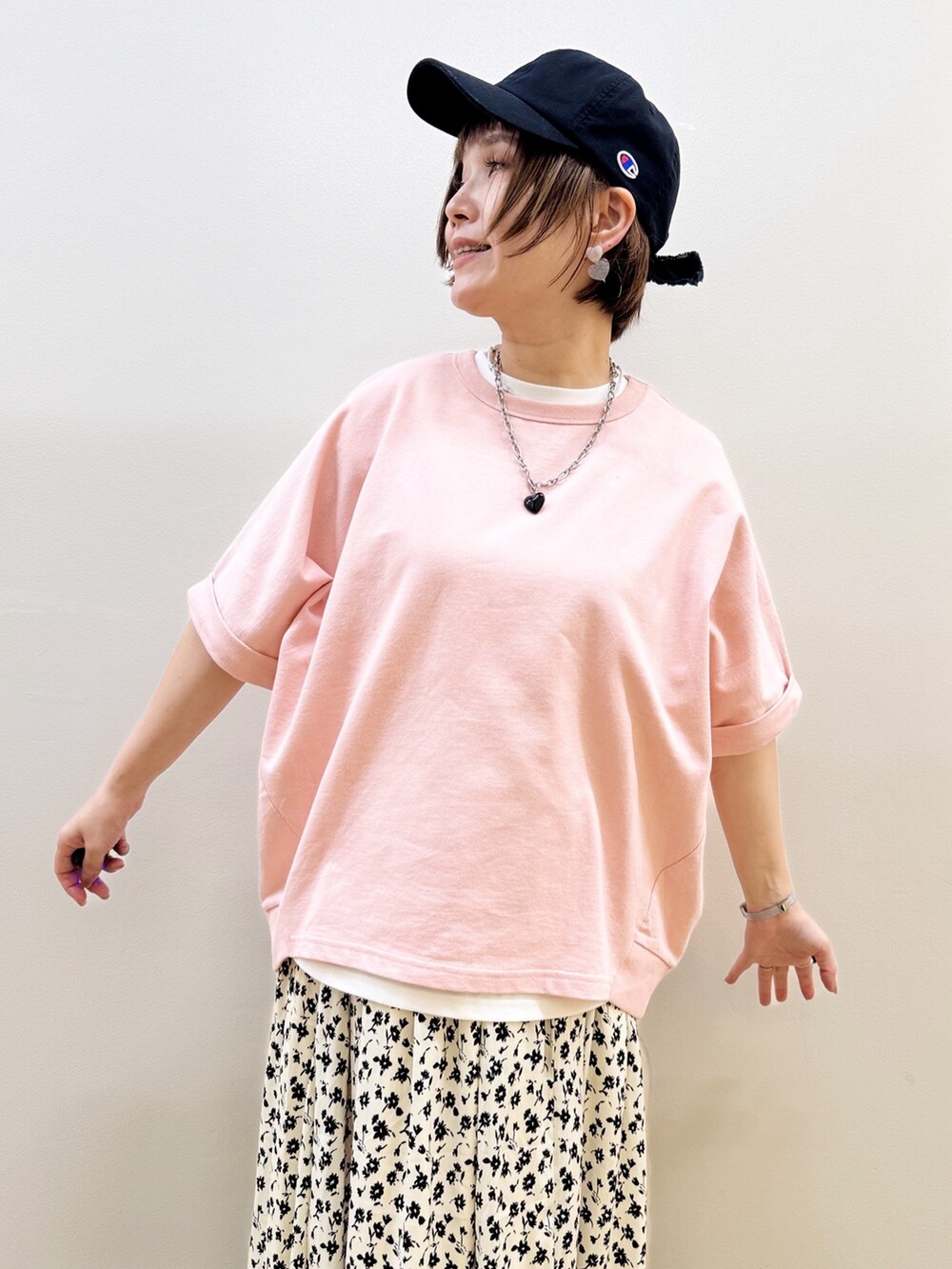 ピンク系のTシャツ/カットソー、ホワイト系のスカート、ブラック系のショルダーバッグを着用したレディースの春コーディネートの4枚目の写真