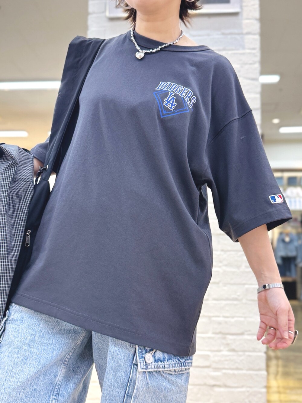 ブラック系のTシャツ/カットソー、ブルー系のその他パンツ、ブラック系のハットを着用したレディースの春コーディネートの3枚目の写真