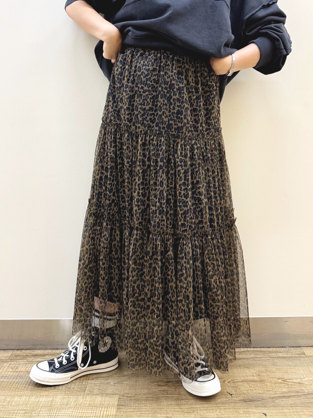 ブラック系のスウェット、ブラウン系のスカート、ホワイト系のショルダーバッグを着用したレディースの秋コーディネートの7枚目の写真