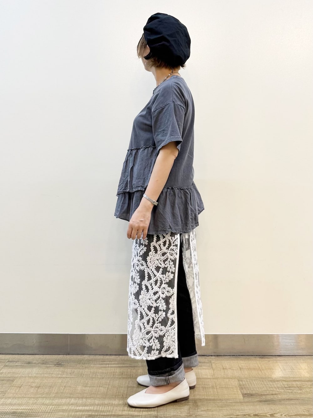 グレー系のTシャツ/カットソー、ホワイト系のスカート、ブラック系のデニムパンツを着用したレディースの春コーディネートの3枚目の写真