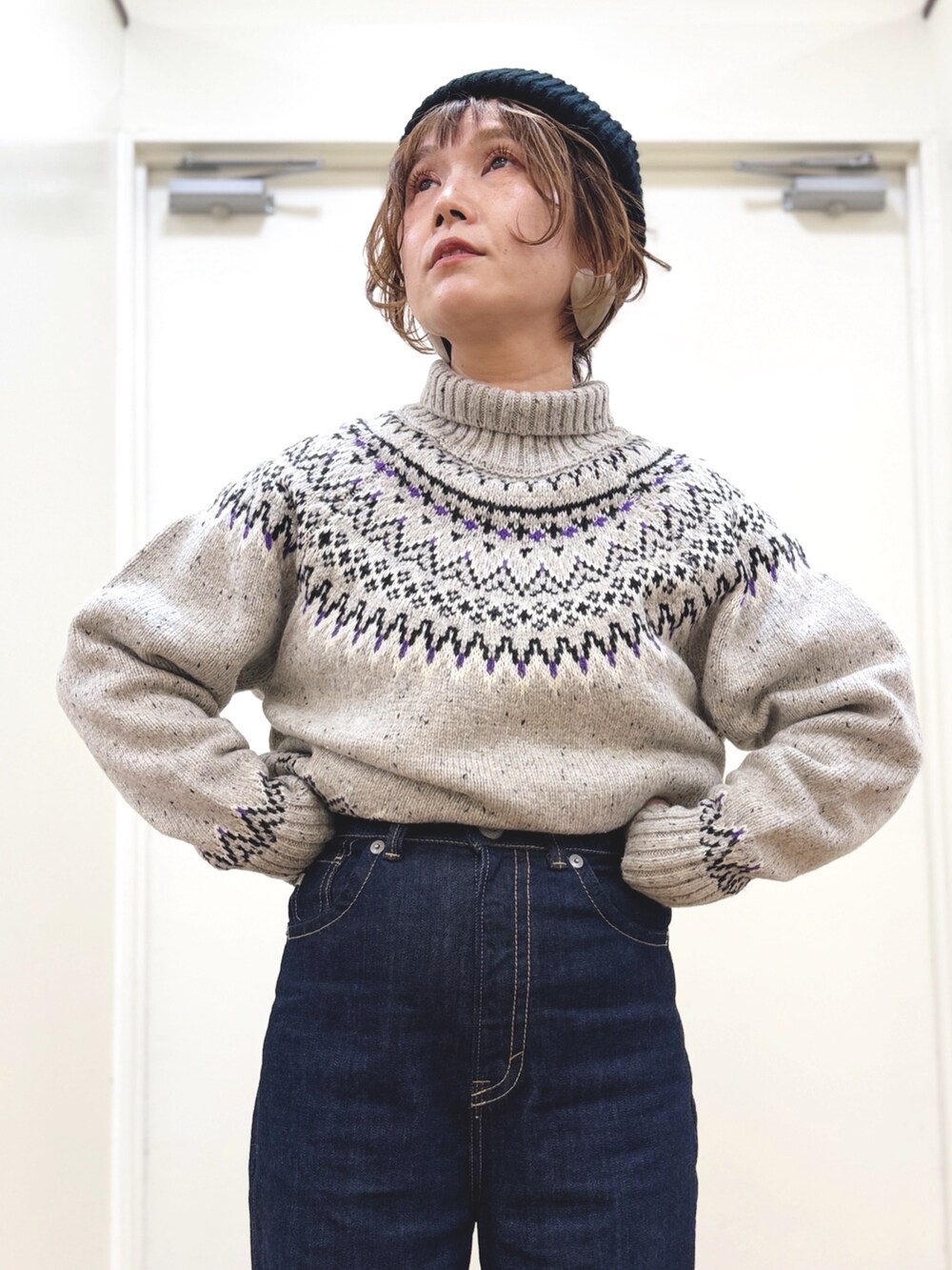 ホワイト系のニット/セーター、ブルー系のデニムパンツ、ブラック系のその他アウターを着用したレディースの冬コーディネートの8枚目の写真