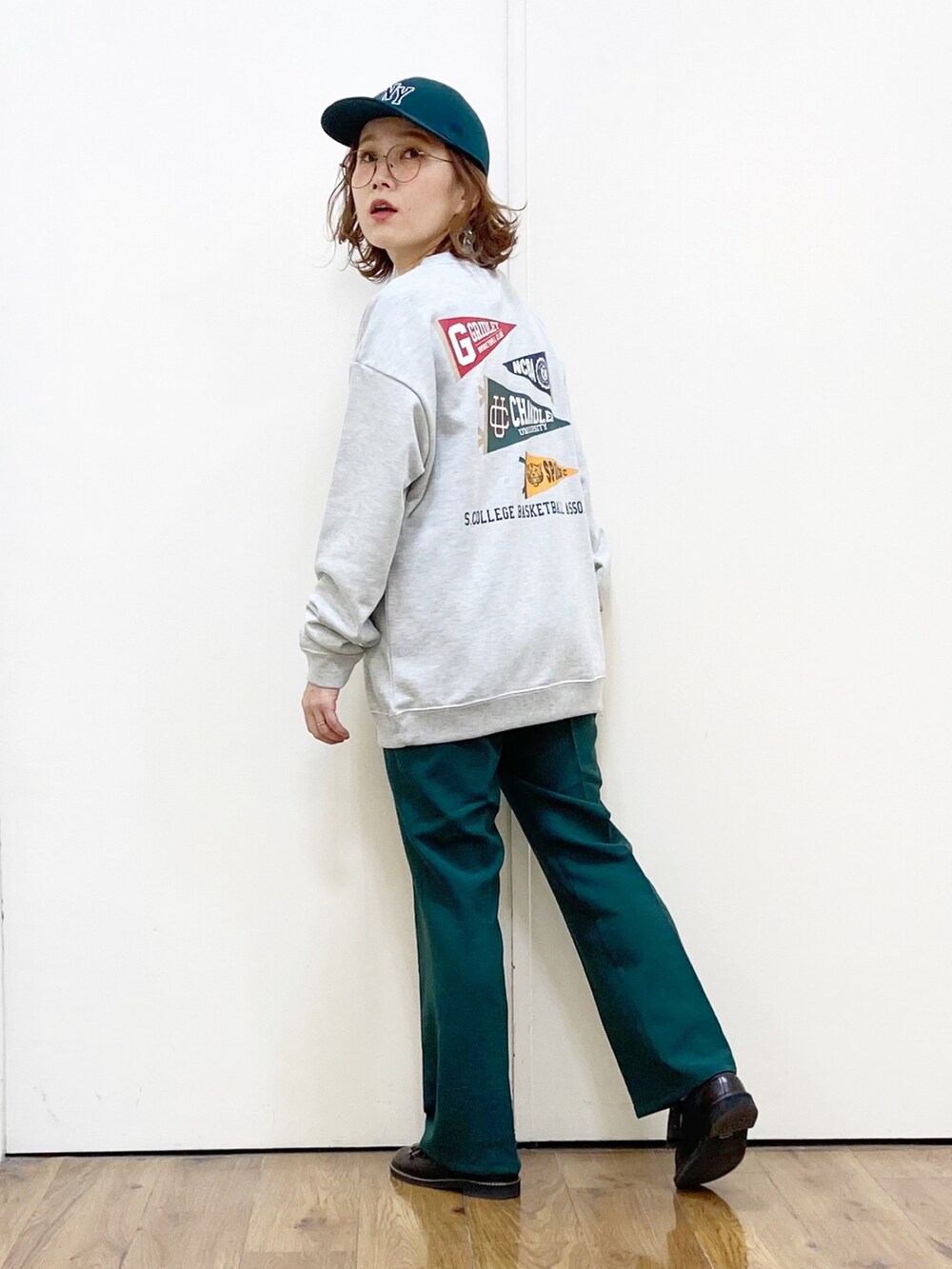 ブラック系のその他パンツ、ブラック系のローファー、グリーン系のスウェットを着用したレディースの冬コーディネートの3枚目の写真