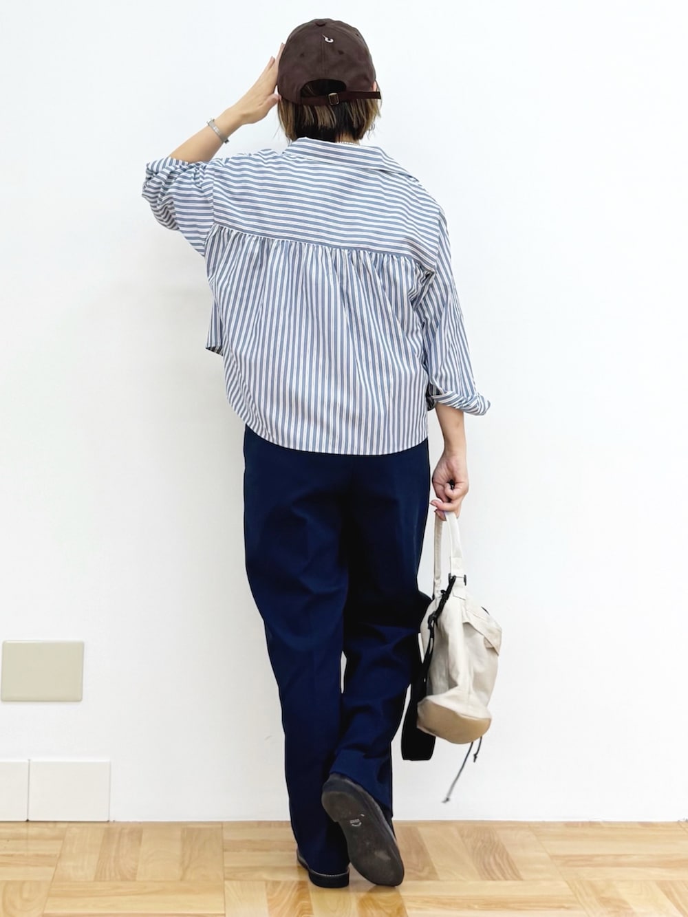 ホワイト系のショルダーバッグ、ブラウン系のドレスシューズ、ブルー系のその他パンツを着用したレディースの秋コーディネートの5枚目の写真