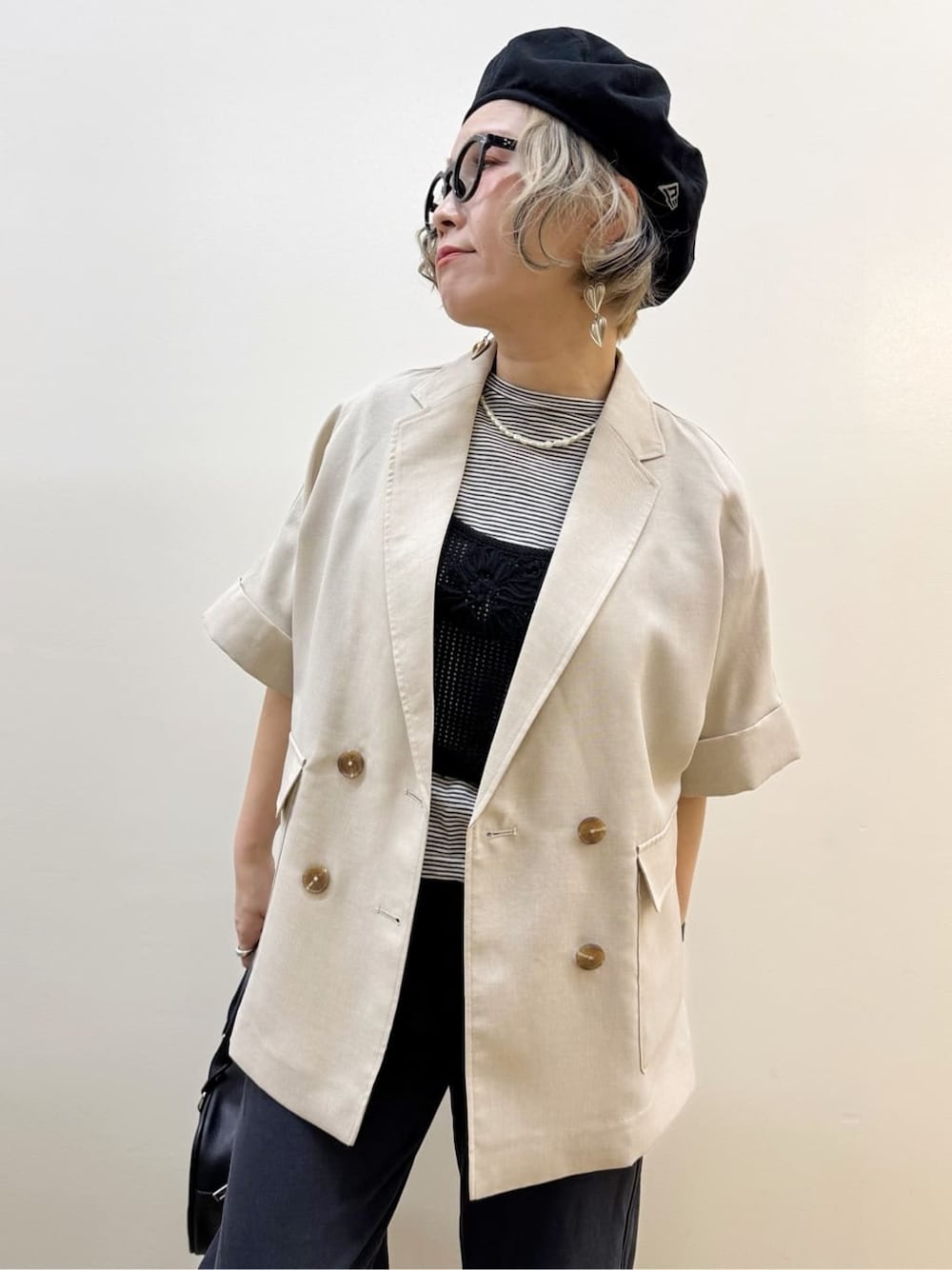 ベージュ系のテーラードジャケット、ホワイト系のTシャツ/カットソー、ブラック系のその他パンツを着用したレディースの春コーディネートの2枚目の写真