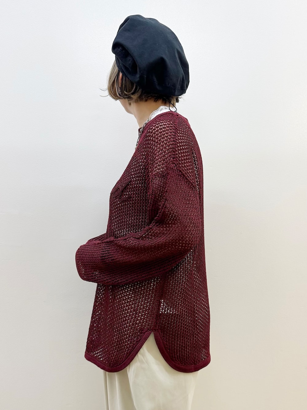 レッド系のニット/セーター、グレー系のその他パンツ、ブラック系のショルダーバッグを着用したレディースの秋コーディネートの4枚目の写真