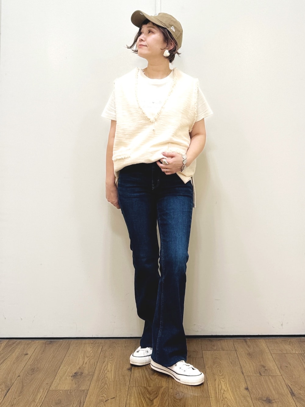 ホワイト系のベスト、ホワイト系のTシャツ/カットソー、ブルー系のデニムパンツを着用したレディースの秋コーディネートの4枚目の写真