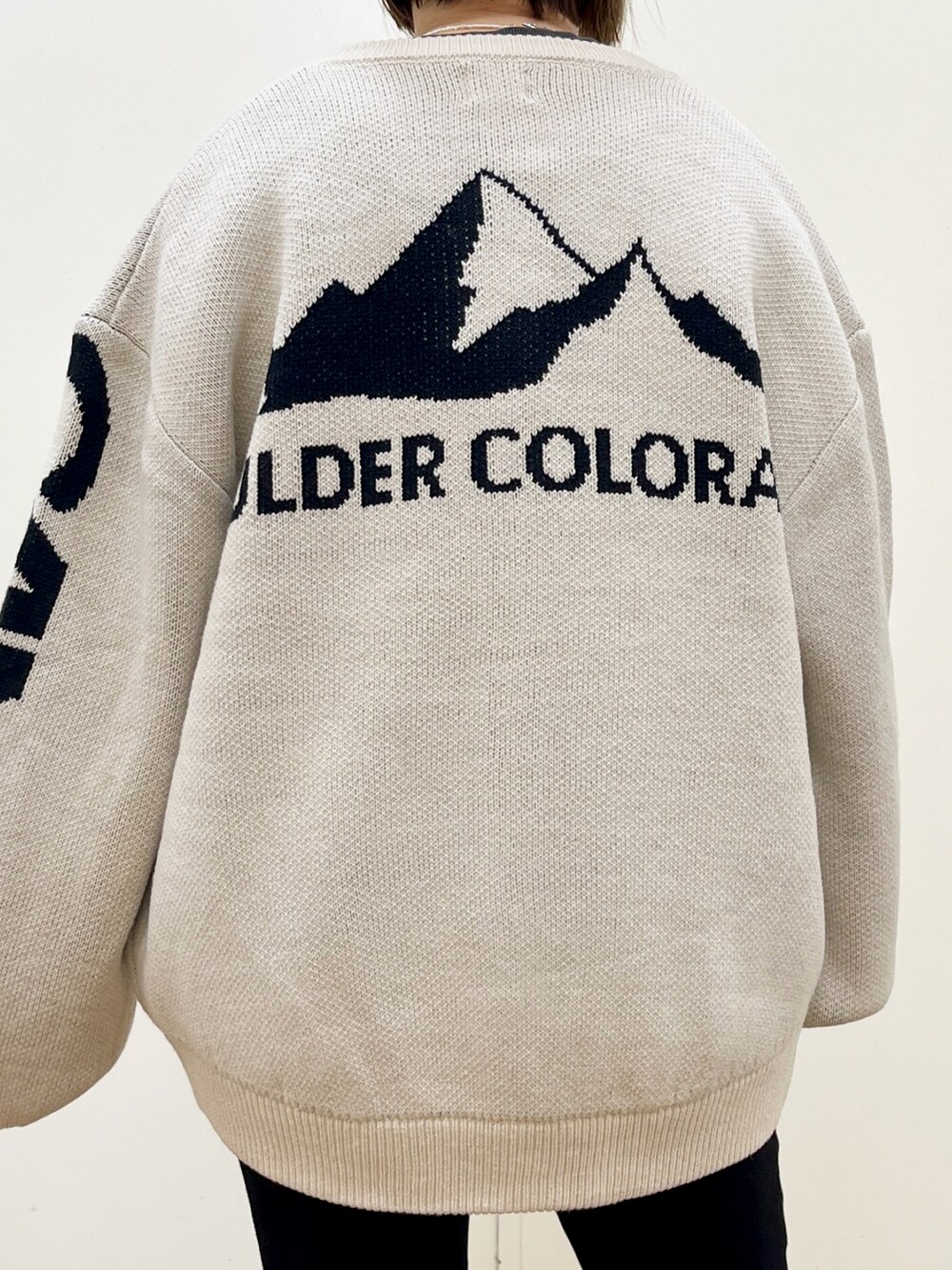 ブラック系のデニムパンツ、イエロー系のスニーカー、ブラック系のショルダーバッグを着用したレディースの秋コーディネートの2枚目の写真