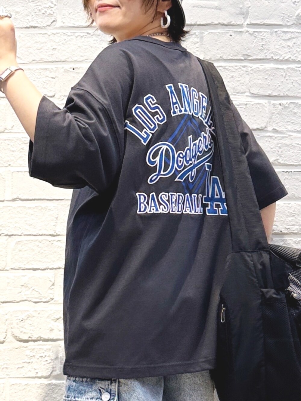 ブラック系のTシャツ/カットソー、ブルー系のその他パンツ、ブラック系のハットを着用したレディースの春コーディネートの2枚目の写真