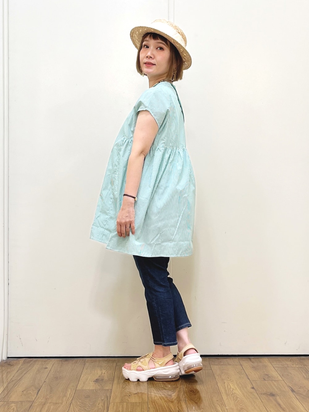 グリーン系のシャツ/ブラウス、ブルー系のデニムパンツ、ベージュ系のサンダルを着用したレディースの夏コーディネートの2枚目の写真