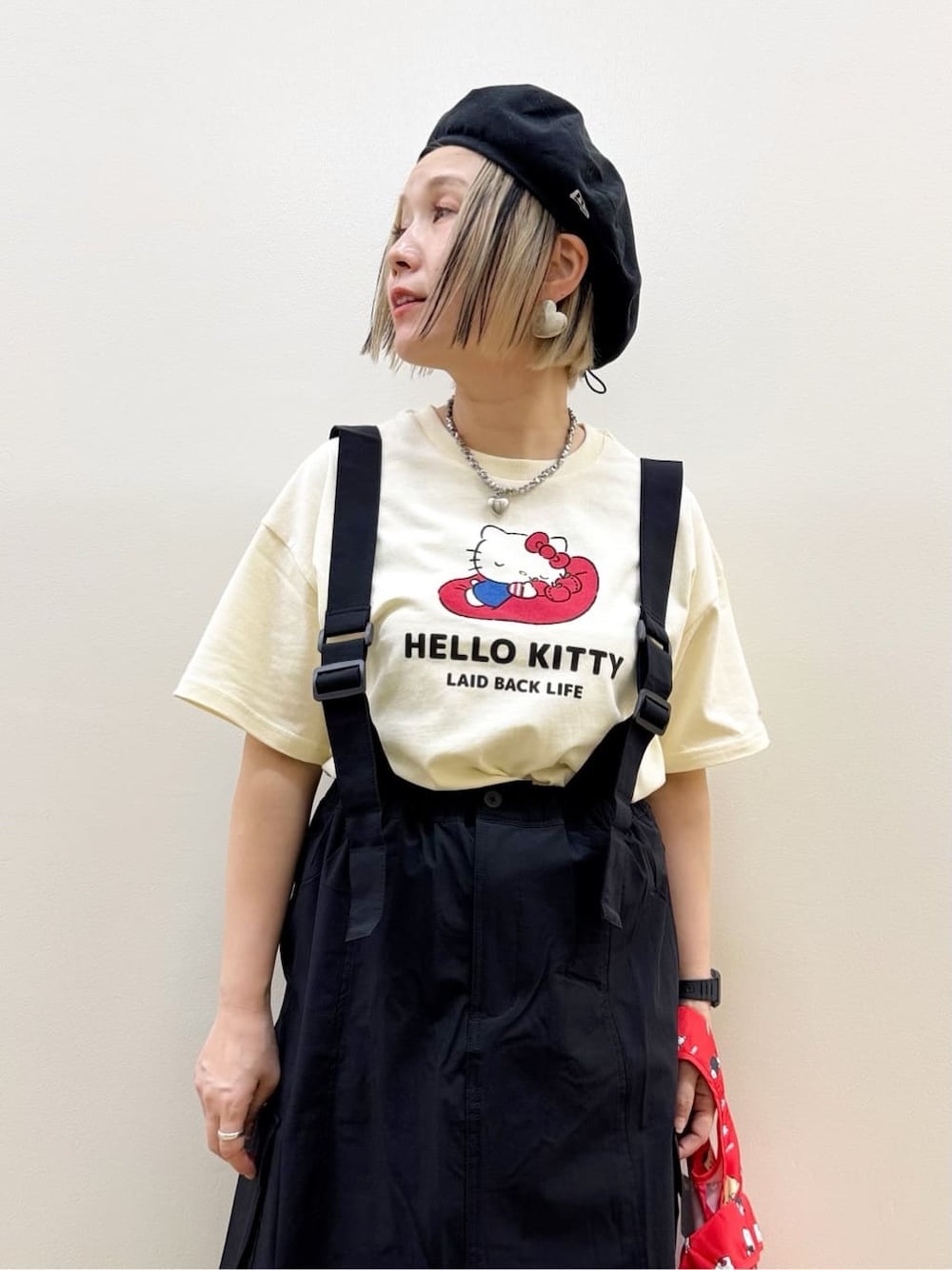 ホワイト系のTシャツ/カットソー、ブラック系のスカート、レッド系のエコバッグ/サブバッグを着用したレディースの春コーディネートの3枚目の写真