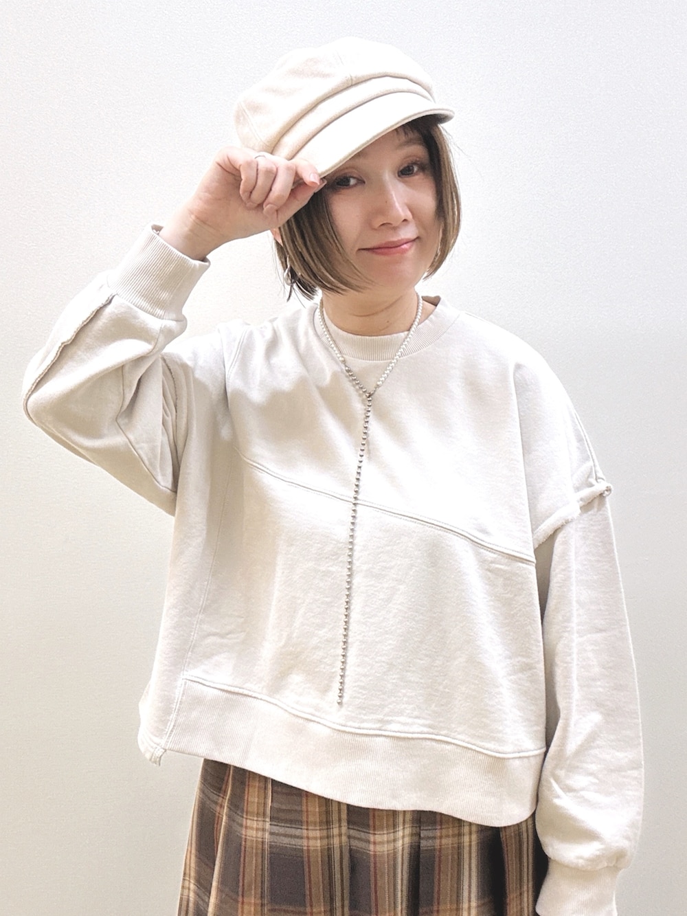 ベージュ系のスウェット、イエロー系のスカート、イエロー系のショルダーバッグを着用したレディースの秋コーディネートの2枚目の写真