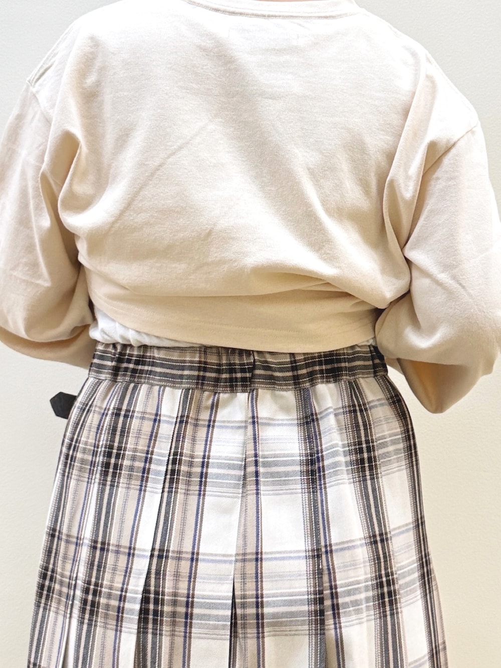 ベージュ系のベスト、ベージュ系のTシャツ/カットソー、ベージュ系のスカートを着用したレディースの秋コーディネートの10枚目の写真