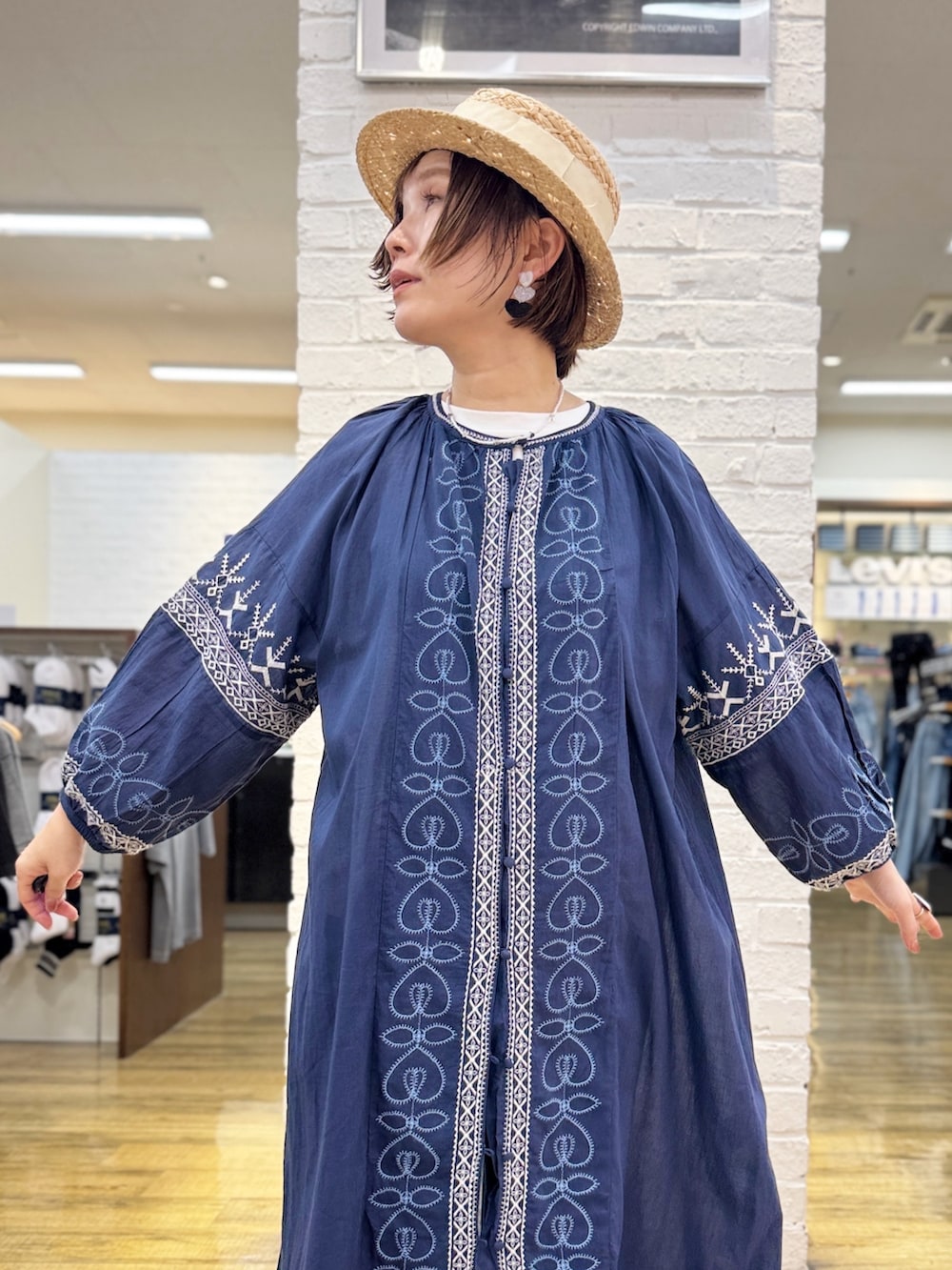 ブルー系のデニムパンツ、ブルー系のシャツワンピース、ホワイト系のTシャツ/カットソーを着用したレディースの春コーディネートの2枚目の写真