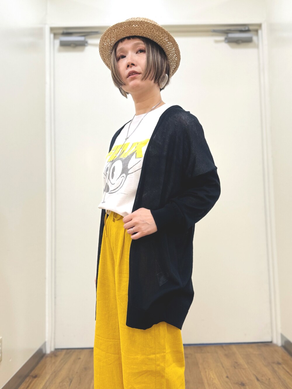 ブラック系のカーディガン/ボレロ、ホワイト系のTシャツ/カットソー、ブラック系のサンダルを着用したレディースの春コーディネートの5枚目の写真