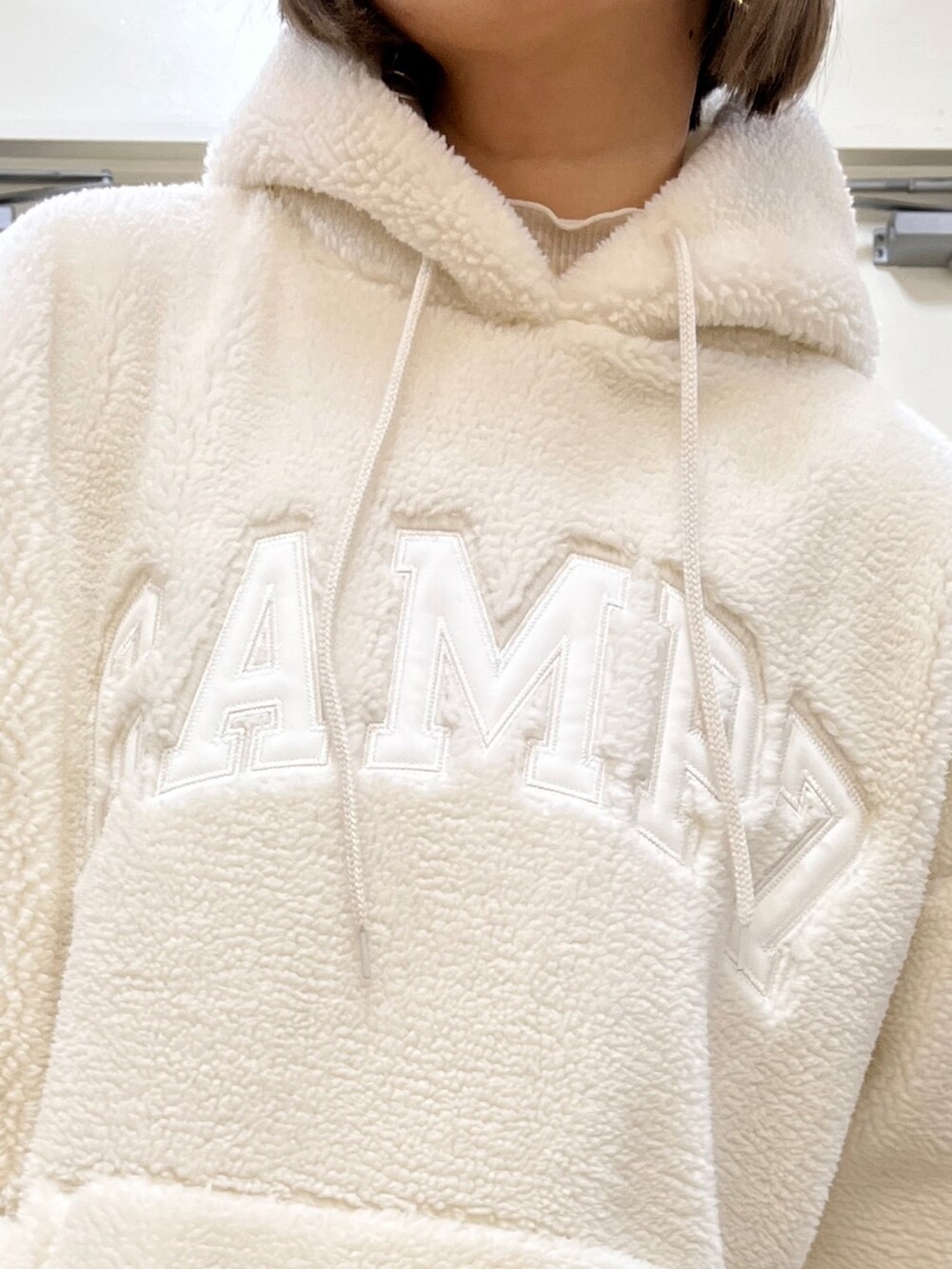 ホワイト系のパーカー、ホワイト系のデニムパンツ、ホワイト系のモカシン/デッキシューズを着用したレディースの冬コーディネートの3枚目の写真
