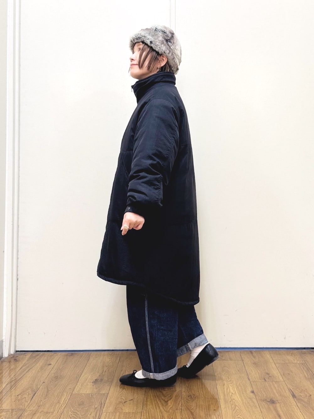 ブルー系のサロペット/オーバーオール、ブラック系のダウンジャケット/コート、レッド系のニット/セーターを着用したレディースの冬コーディネートの7枚目の写真