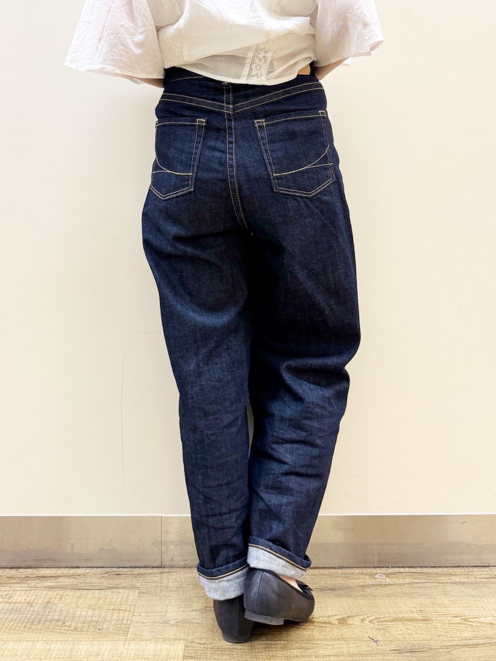 ブラック系のバレエシューズ、ゴールド系のかごバッグ、ブルー系のデニムパンツを着用したレディースの夏コーディネートの10枚目の写真