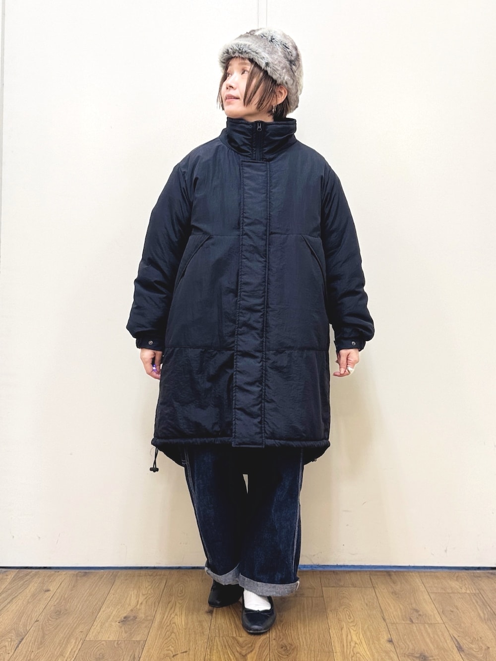 ブルー系のサロペット/オーバーオール、ブラック系のダウンジャケット/コート、レッド系のニット/セーターを着用したレディースの冬コーディネートの6枚目の写真