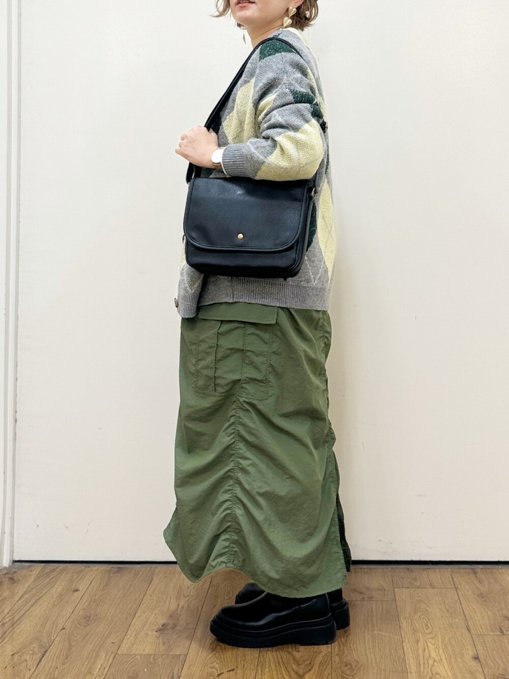 グリーン系のスカート、ブラック系のショルダーバッグ、グリーン系のカーディガン/ボレロを着用したレディースの秋コーディネートの9枚目の写真