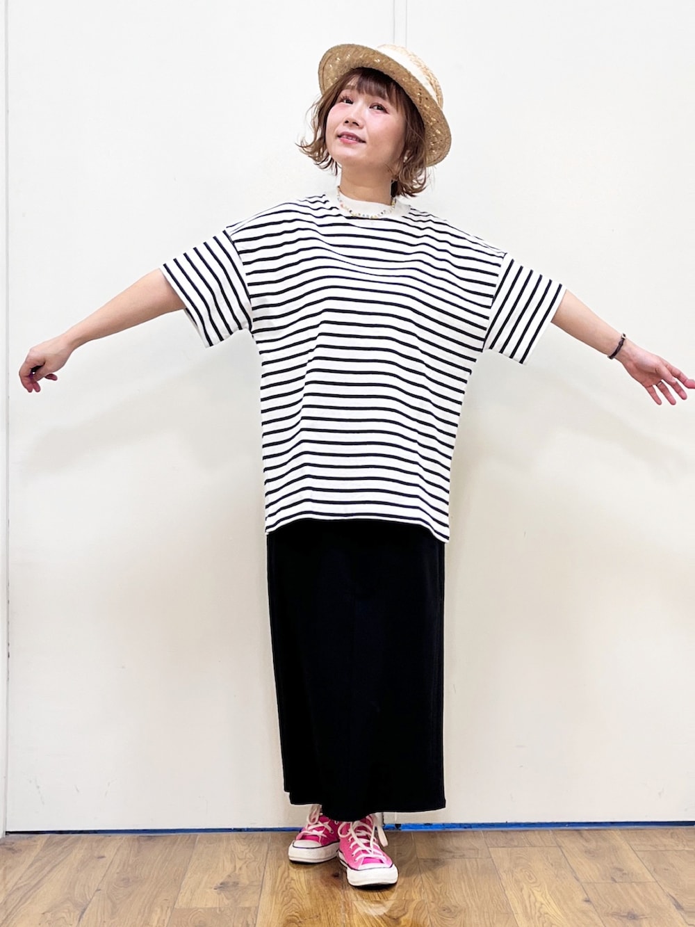 ブラック系のスカート、ホワイト系のTシャツ/カットソー、ブラウン系のベストを着用したレディースの春コーディネートの3枚目の写真