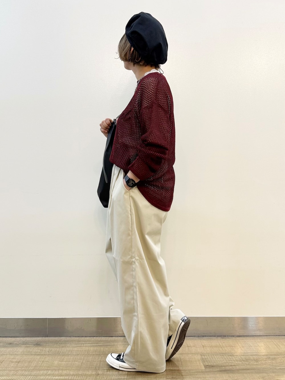 レッド系のニット/セーター、グレー系のその他パンツ、ブラック系のショルダーバッグを着用したレディースの秋コーディネートの3枚目の写真