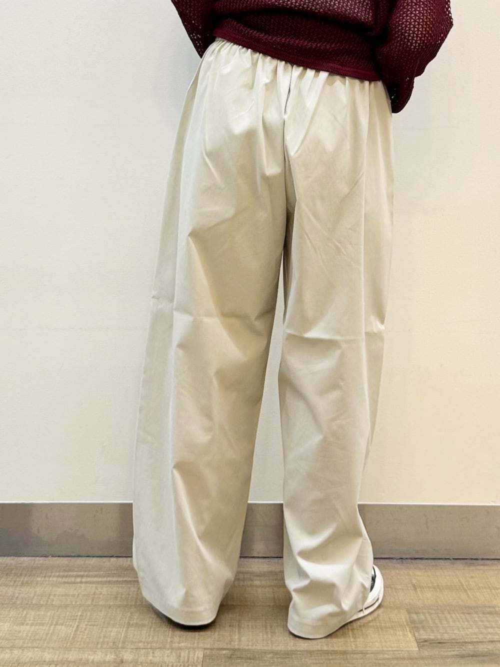 レッド系のニット/セーター、グレー系のその他パンツ、ブラック系のショルダーバッグを着用したレディースの秋コーディネートの9枚目の写真