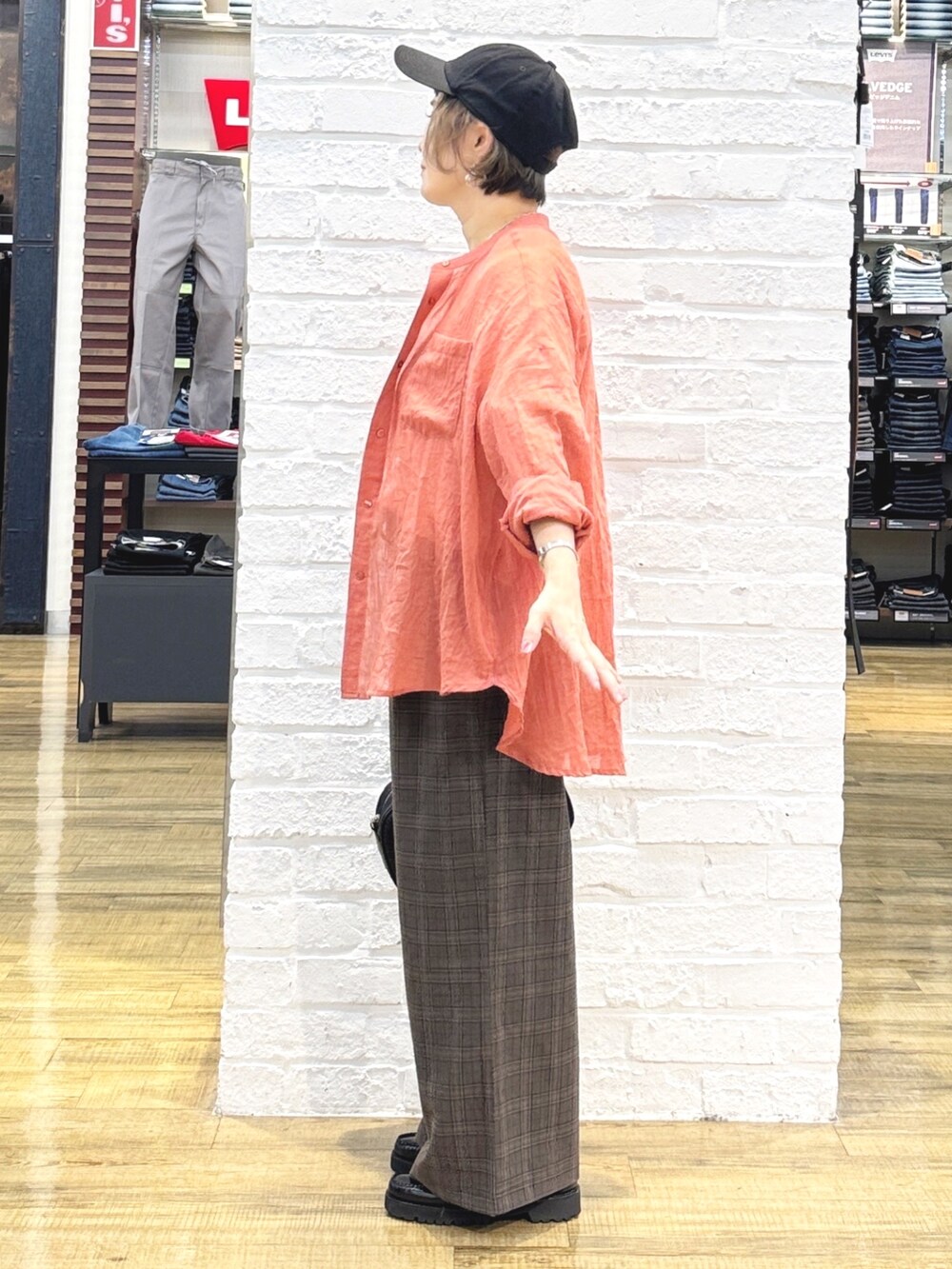 ホワイト系のTシャツ/カットソー、オレンジ系のシャツ/ブラウス、ブラック系のショルダーバッグを着用したレディースの秋コーディネートの5枚目の写真