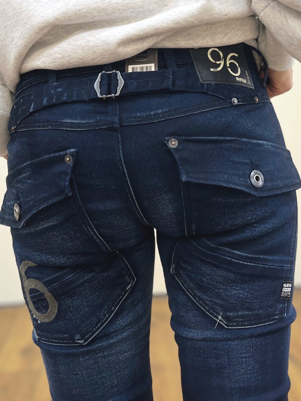 グレー系のスウェット、ブルー系のデニムパンツ、ブルー系のマウンテンパーカーを着用したレディースの冬コーディネートの5枚目の写真