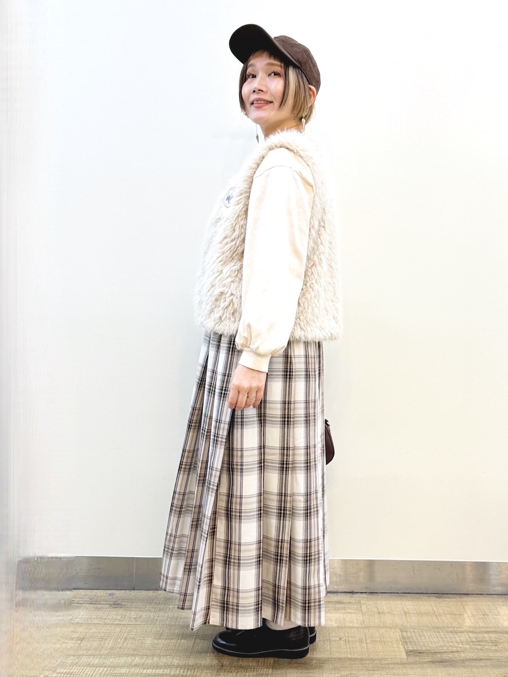 ベージュ系のベスト、ベージュ系のTシャツ/カットソー、ベージュ系のスカートを着用したレディースの秋コーディネートの3枚目の写真