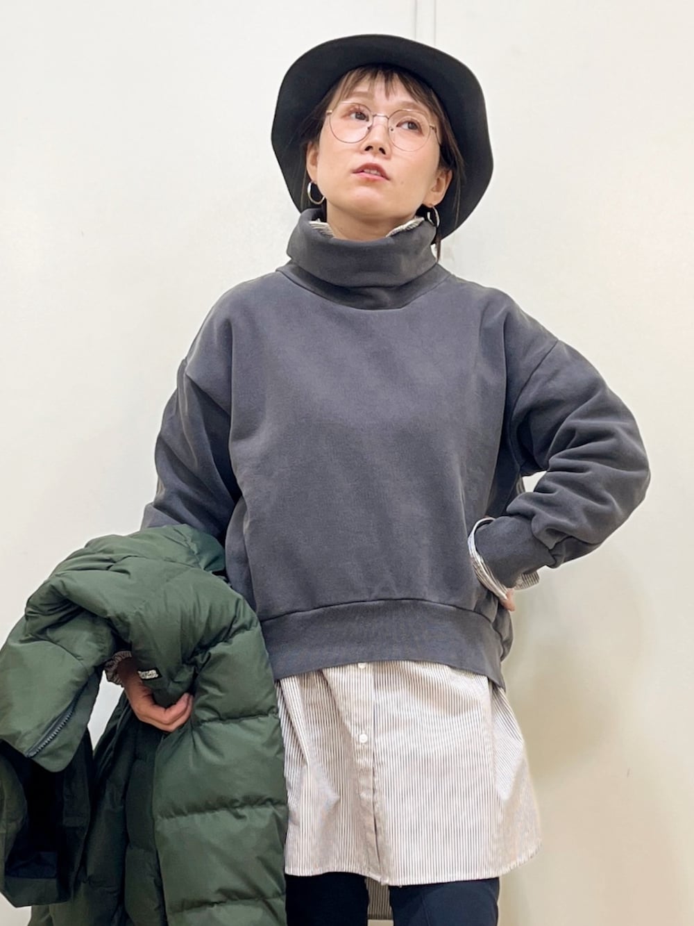 グリーン系のダウンジャケット/コート、ブラウン系のシャツ/ブラウス、グレー系のスウェットを着用したレディースの冬コーディネートの5枚目の写真