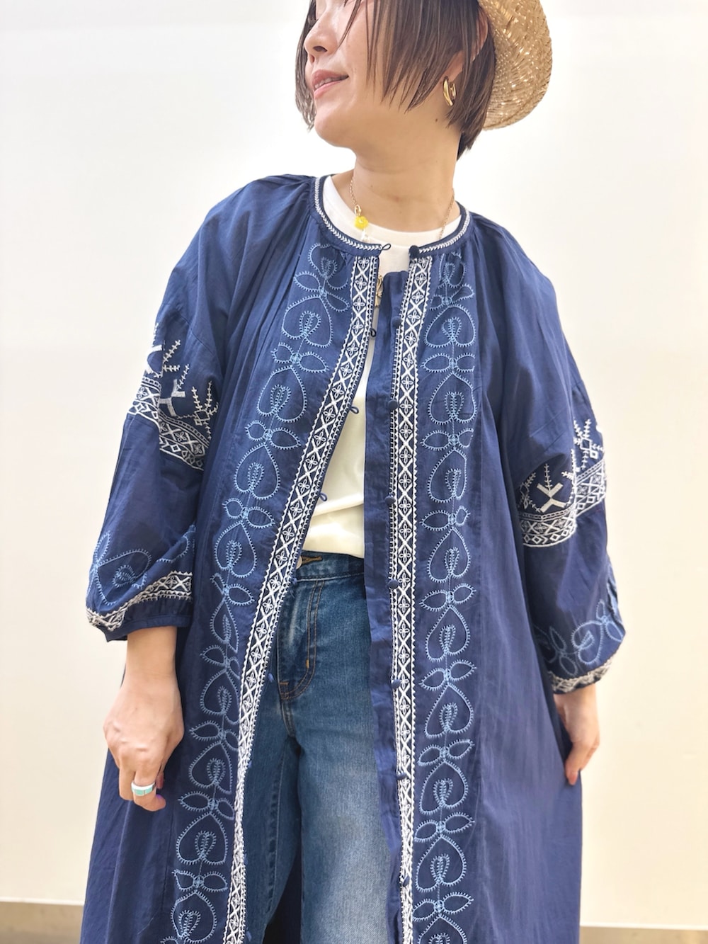 ホワイト系のTシャツ/カットソー、ブルー系のデニムパンツ、ゴールド系のハンドバッグを着用したレディースの夏コーディネートの3枚目の写真