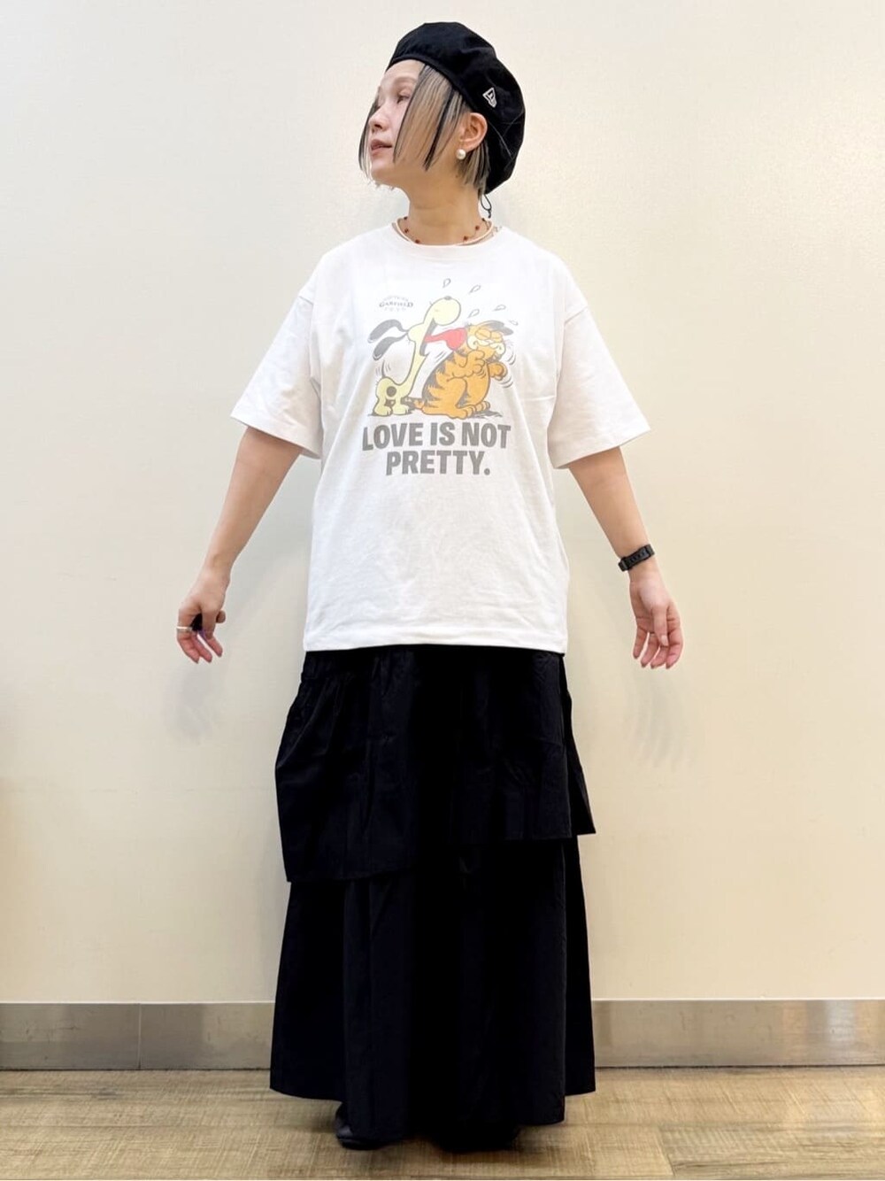 ホワイト系のTシャツ/カットソー、ブラック系のスカート、ホワイト系のショルダーバッグを着用したレディースの春コーディネートの3枚目の写真
