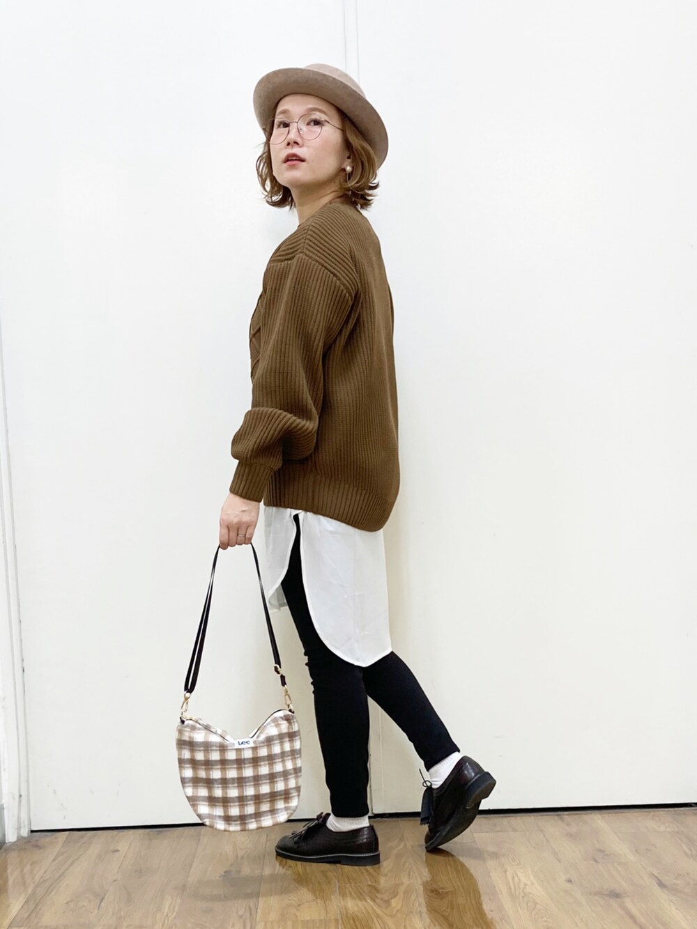 ブラウン系のニット/セーター、ホワイト系のTシャツ/カットソー、ブラック系のその他パンツを着用したレディースの秋コーディネートの2枚目の写真