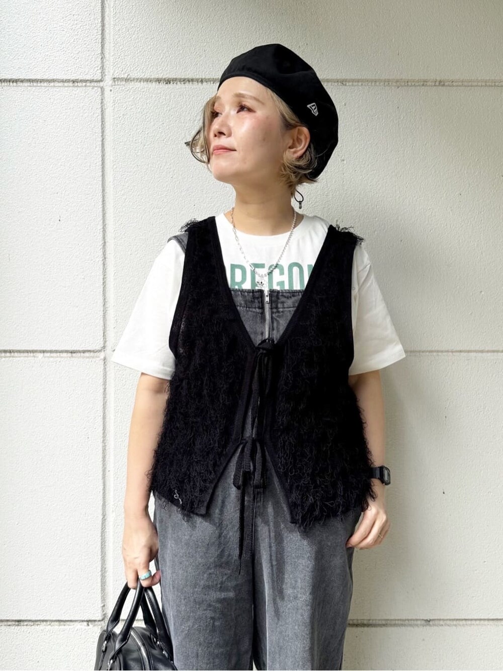 ホワイト系のTシャツ/カットソー、ブラック系のサロペット/オーバーオール、ブラック系のベストを着用したレディースの春コーディネートの3枚目の写真