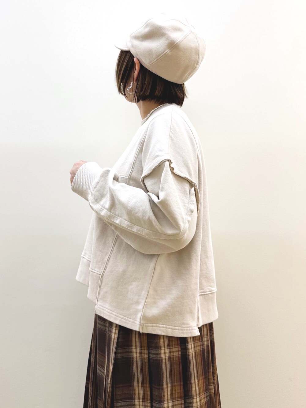 ベージュ系のスウェット、イエロー系のスカート、イエロー系のショルダーバッグを着用したレディースの秋コーディネートの4枚目の写真