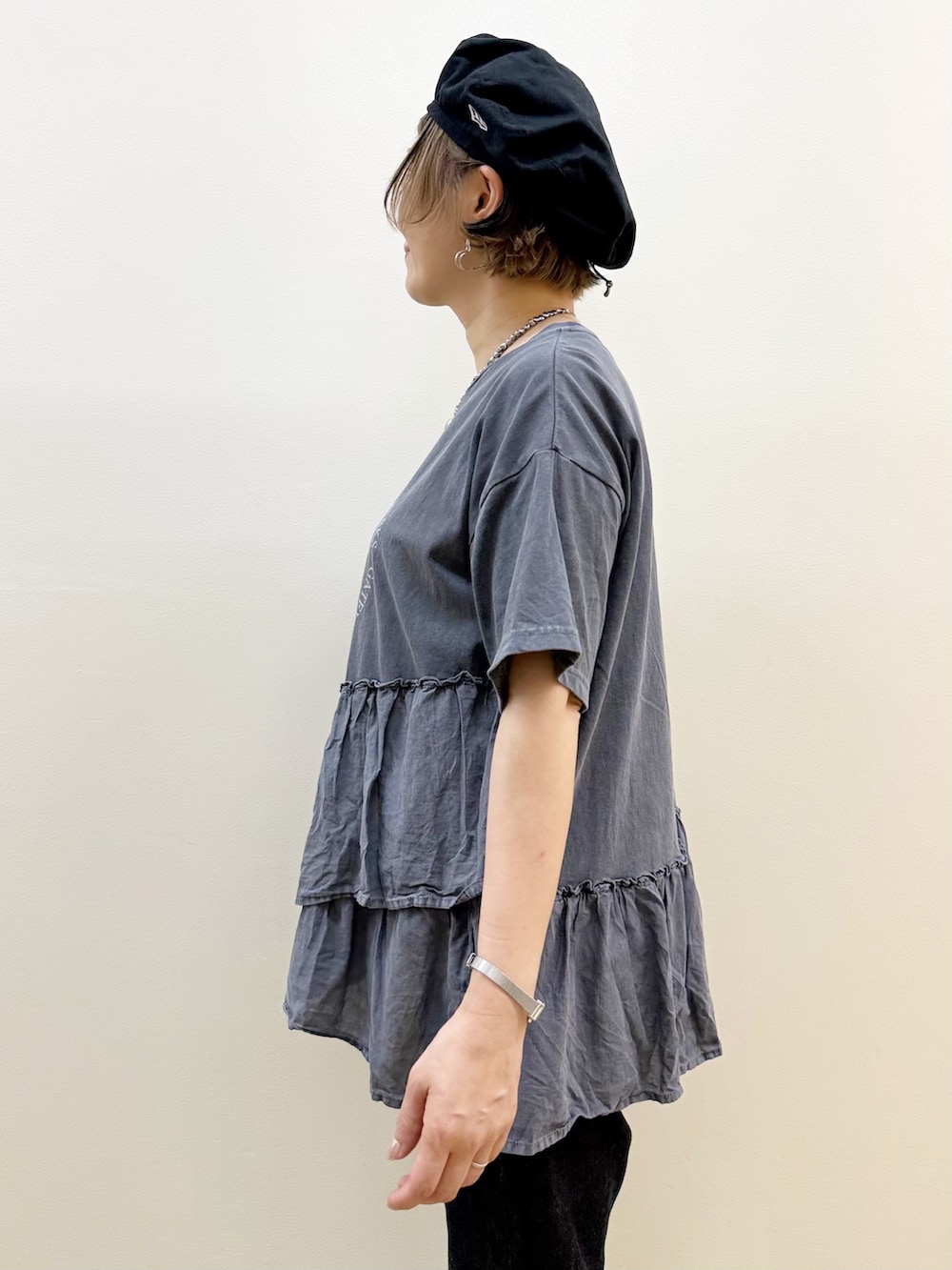 グレー系のTシャツ/カットソー、ホワイト系のスカート、ブラック系のデニムパンツを着用したレディースの春コーディネートの4枚目の写真