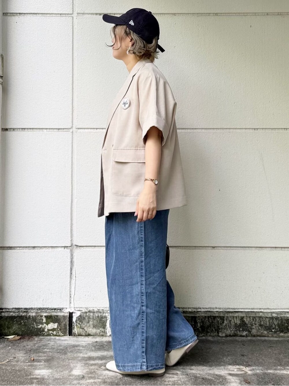 ベージュ系のテーラードジャケット、ブルー系のデニムパンツ、ホワイト系のTシャツ/カットソーを着用したレディースの春コーディネートの3枚目の写真