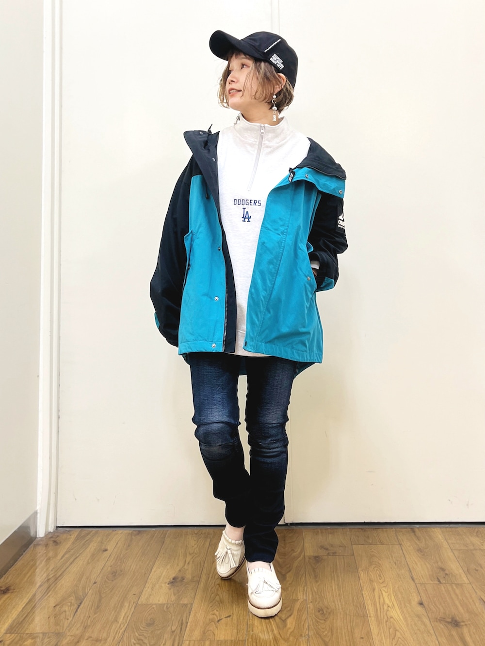 グレー系のスウェット、ブルー系のデニムパンツ、ブルー系のマウンテンパーカーを着用したレディースの冬コーディネートの3枚目の写真