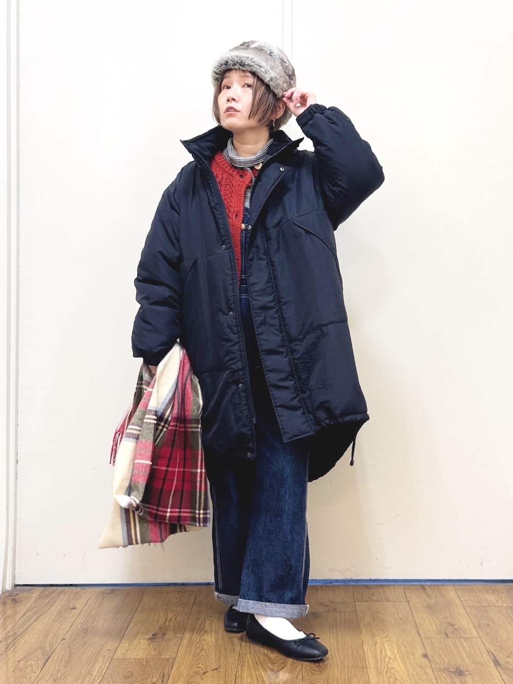 ブルー系のサロペット/オーバーオール、ブラック系のダウンジャケット/コート、レッド系のニット/セーターを着用したレディースの冬コーディネートの5枚目の写真