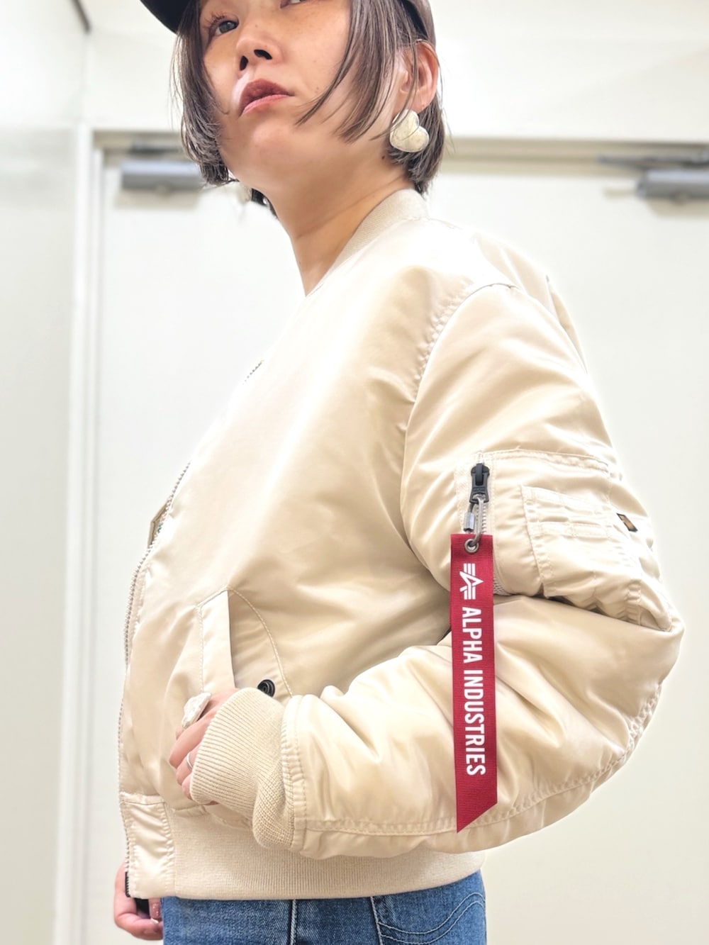 ホワイト系のMA-1、ブルー系のデニムパンツ、ブラウン系のアンサンブルを着用したレディースの秋コーディネートの3枚目の写真