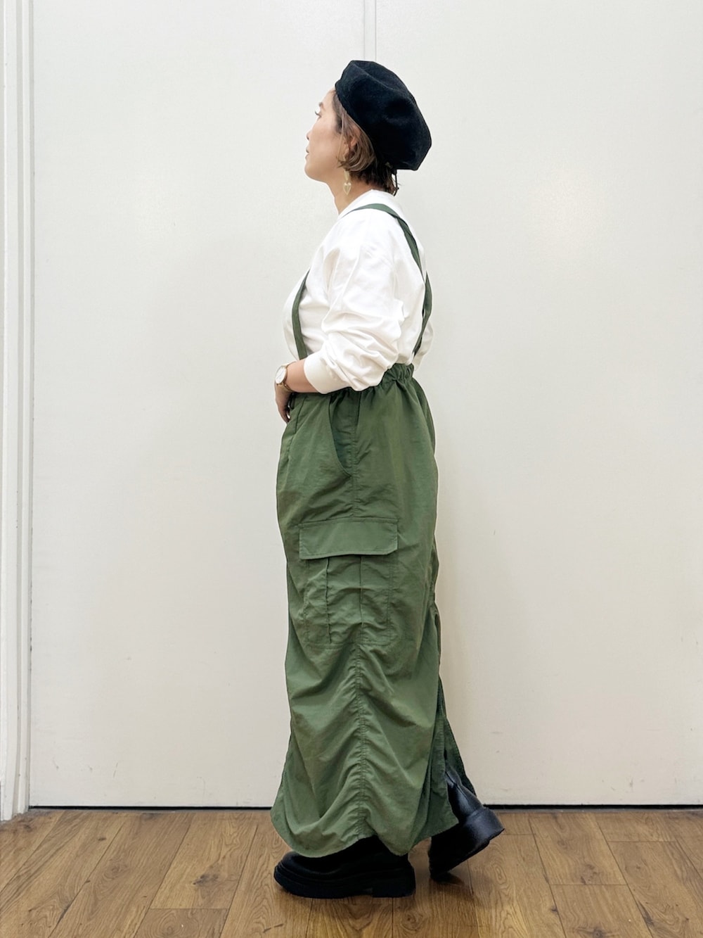 グリーン系のスカート、ブラック系のショルダーバッグ、グリーン系のカーディガン/ボレロを着用したレディースの秋コーディネートの6枚目の写真