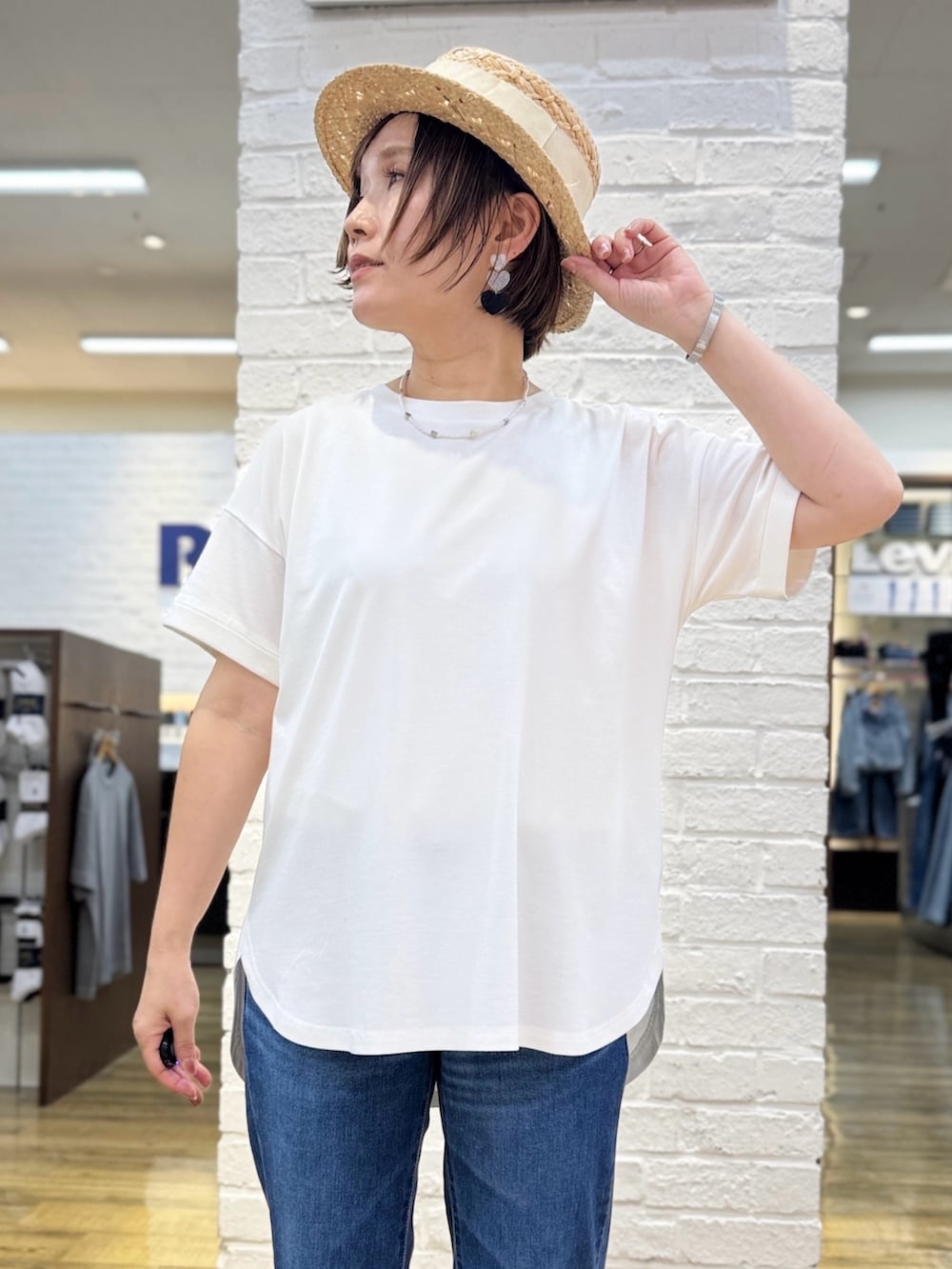 ブルー系のデニムパンツ、ブルー系のシャツワンピース、ホワイト系のTシャツ/カットソーを着用したレディースの春コーディネートの6枚目の写真