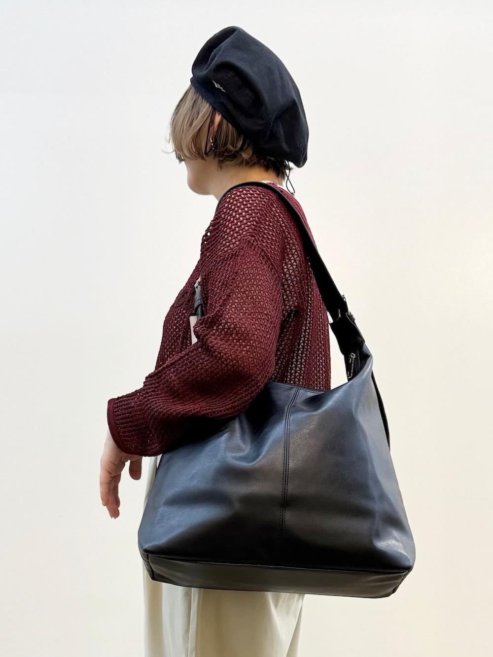 レッド系のニット/セーター、グレー系のその他パンツ、ブラック系のショルダーバッグを着用したレディースの秋コーディネートの10枚目の写真