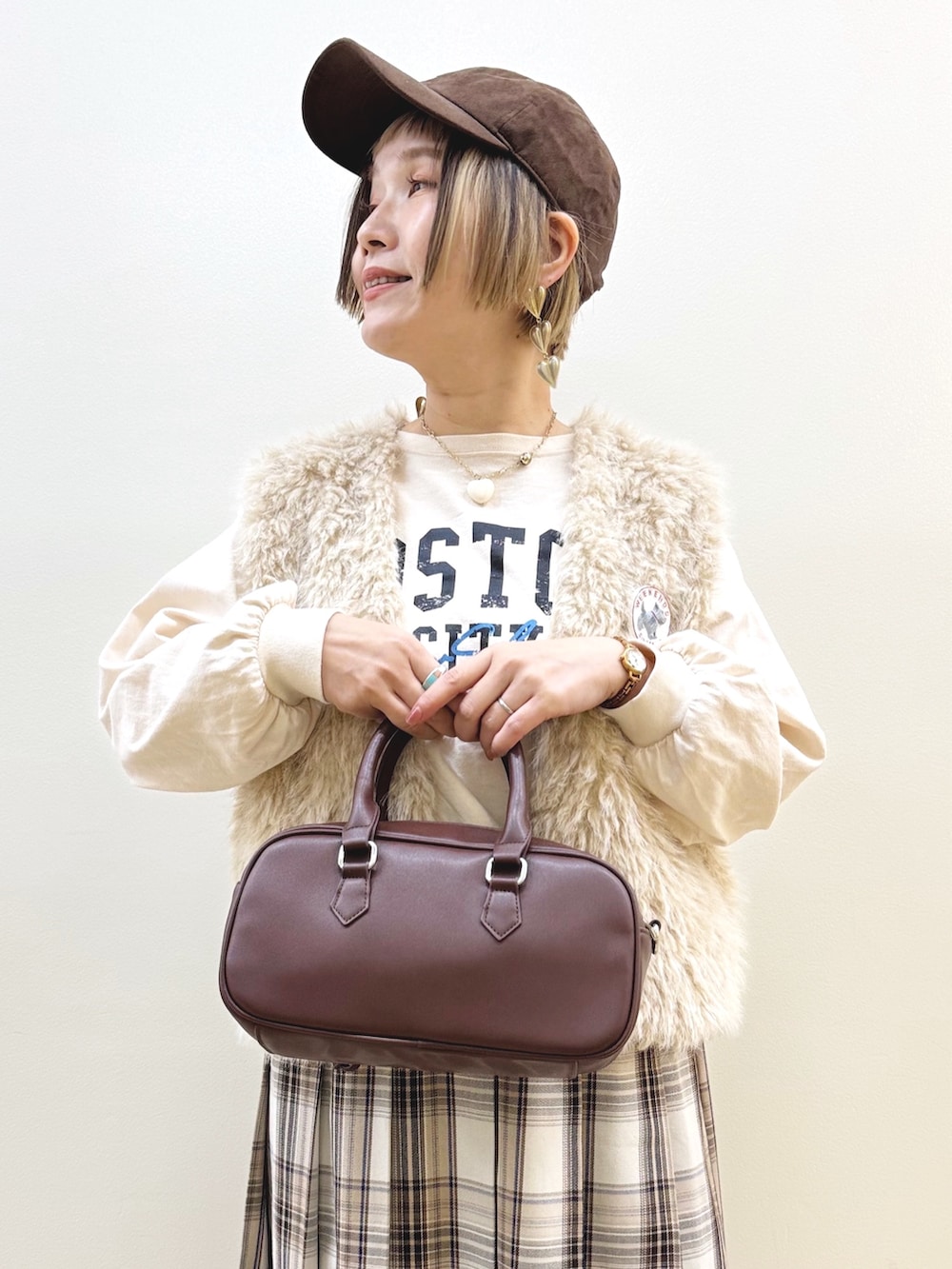 ベージュ系のベスト、ベージュ系のTシャツ/カットソー、ベージュ系のスカートを着用したレディースの秋コーディネートの6枚目の写真