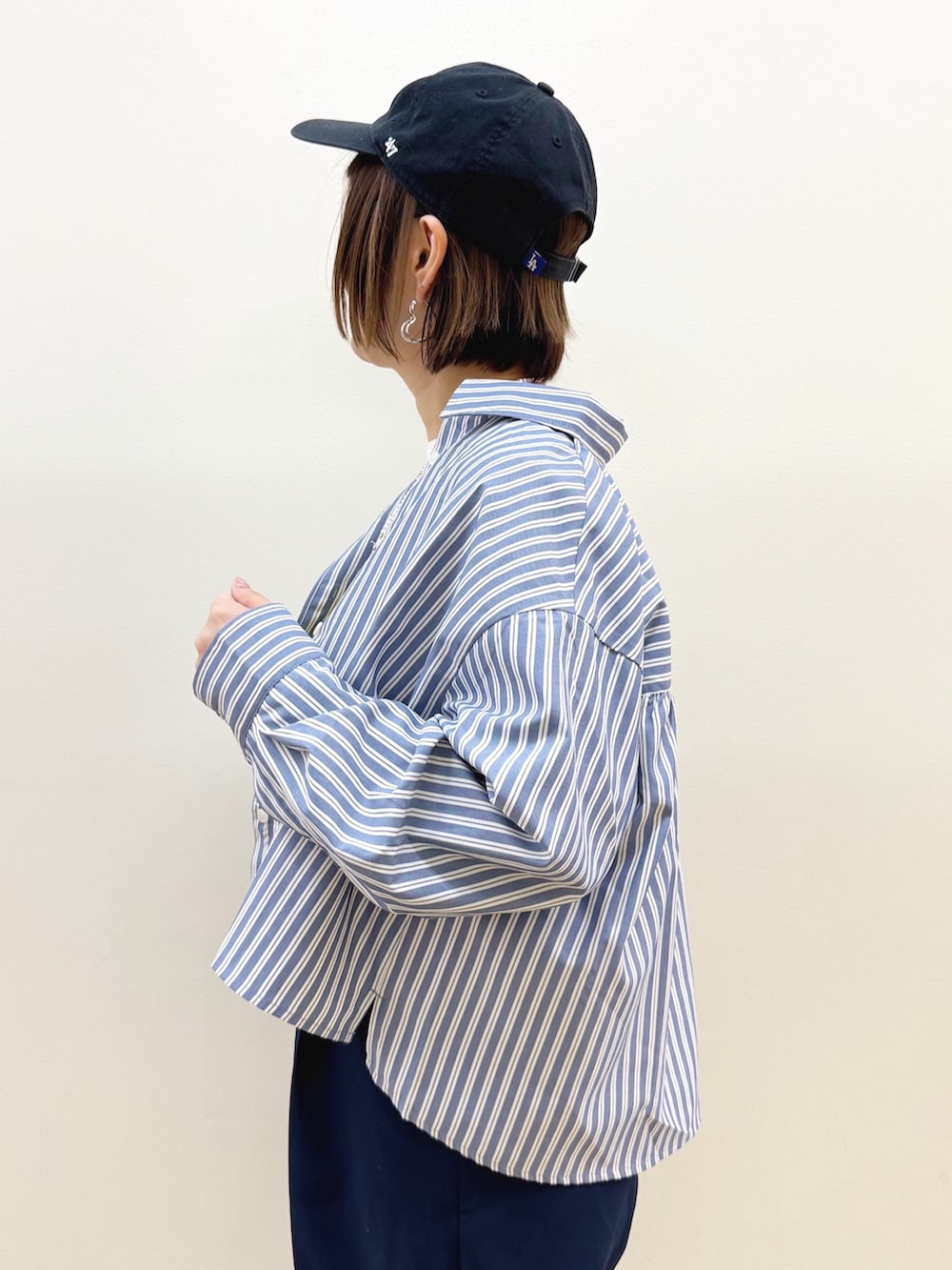 ホワイト系のショルダーバッグ、ブラウン系のドレスシューズ、ブルー系のその他パンツを着用したレディースの秋コーディネートの4枚目の写真