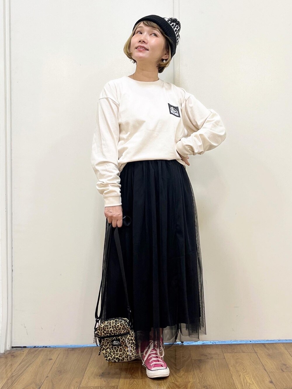 ホワイト系のTシャツ/カットソー、ブラック系のスカート、ベージュ系のショルダーバッグを着用したレディースの秋コーディネートの3枚目の写真