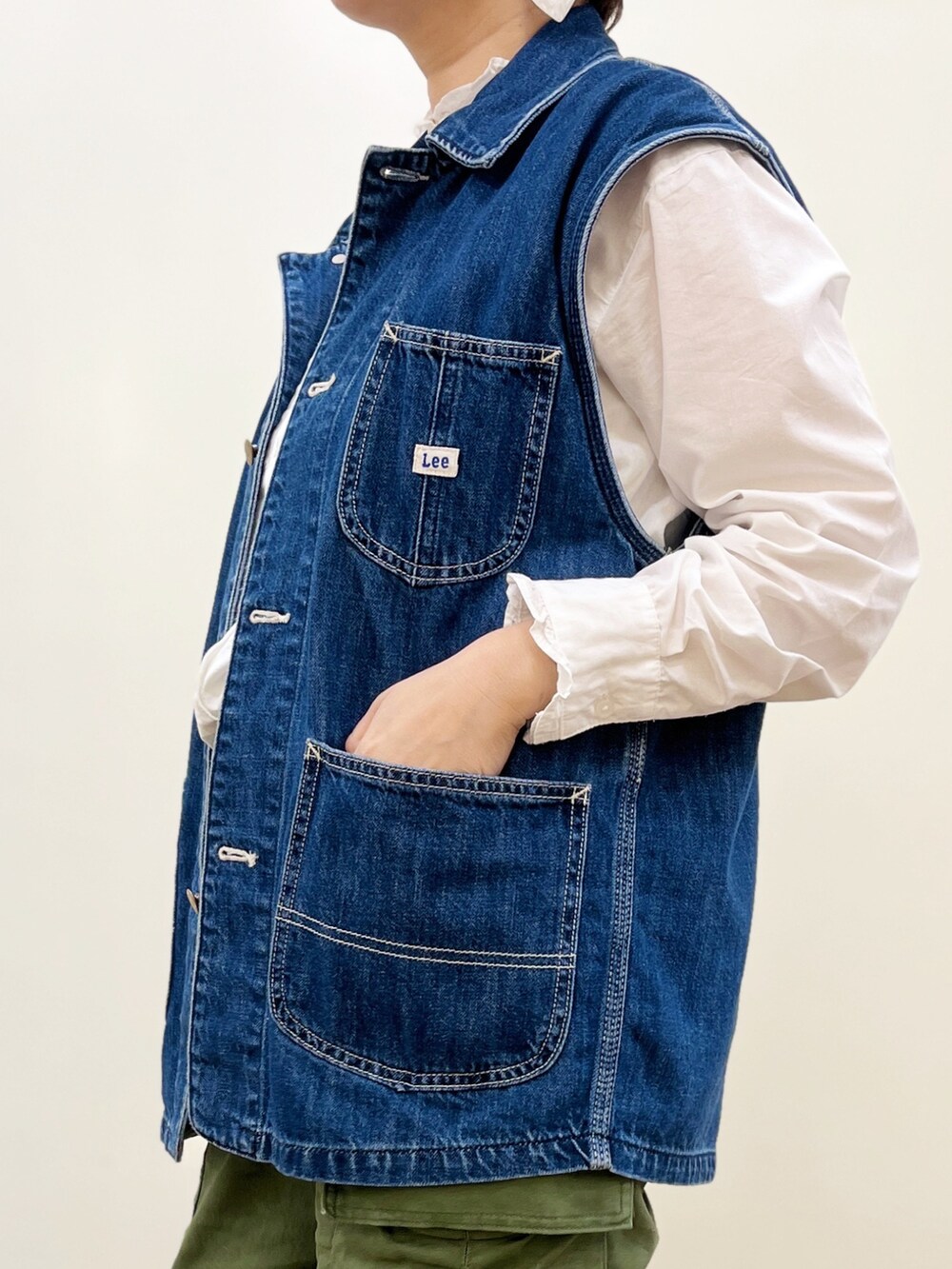 ブラウン系のその他パンツ、ブルー系のベスト、ホワイト系のシャツ/ブラウスを着用したレディースの春コーディネートの3枚目の写真